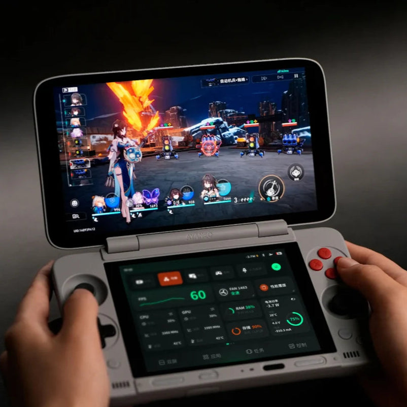 Handheld gaming console with two screens displaying a game, held by a person.